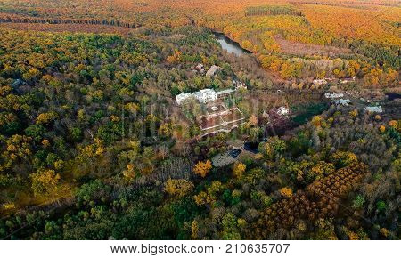 Aerial view on abandoned ruined castle and park. Autumn color image in sunset light.