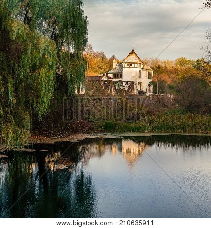 View on abandoned ruined castle and park. Autumn color image in sunset light.