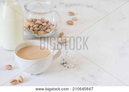 Coffee With Milk And Pistachios On Wooden Table, Copy Space