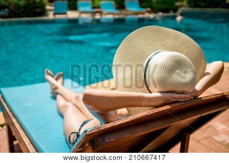 Women wearing bikini or swimware suits at swimming pool relax on the pool bed at the resort of Pattaya in Thailand.