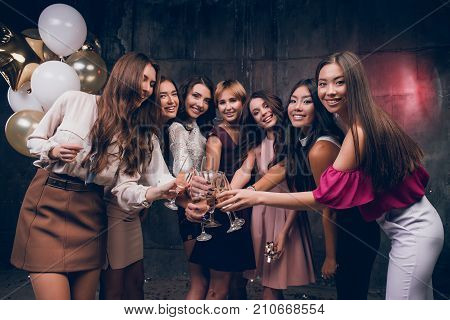 Beautiful girlfriends looking at the camera and smiling. Celebrate Christmas Ewe in the club with friends. New Year holiday with best friends.