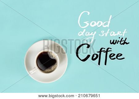 Top view of cup of black coffee and Good day start with Coffee lettering isolated on blue background. Still life. Mock up. Flat lay