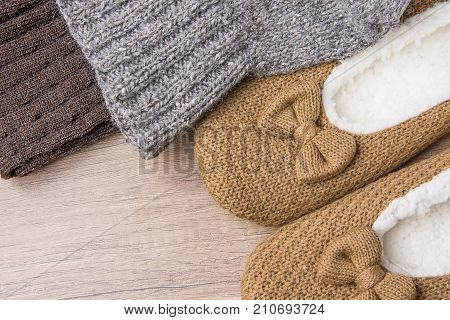 Handmade Warm Knitted Socks From Coarse Wool Yarn Fluffy Fur Slippers on Wood Background. Winter Autumn Eco Fashion Kinfolk Style. Natural Materials.