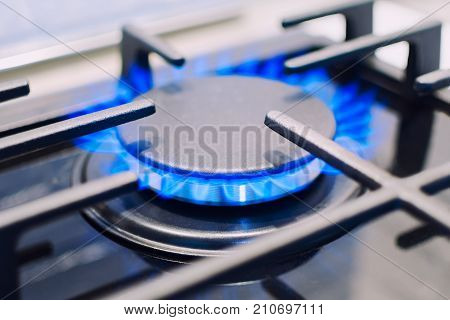 Burning gas burner on the stove. Photo with shallow depth of focus.
