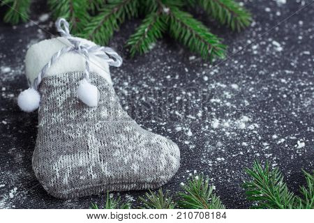 Christmas Grey Stocking On Snowbound Black Background With Fir Branches