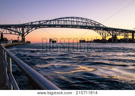 Port Huron, Michigan, USA - October 5, 2017: A freighter travels beneath the twin spans of the Blue Water Bridge international border crossing. The bridge connects Michigan, USA and Ontario, Canada.