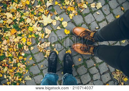 couple boots top view with yellow autumn leaves