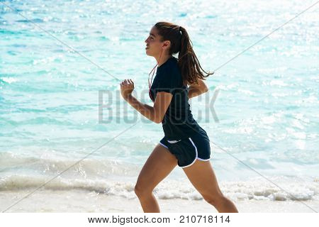 Latin girl running in caribbean shore beach of Mayan Riviera of Mexico