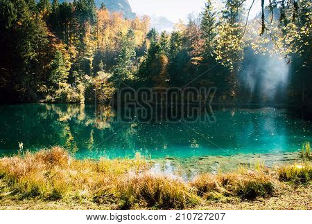 Autumn time at romantic forest lake Blausee, one of the best known mountain lakes in Switzerland.