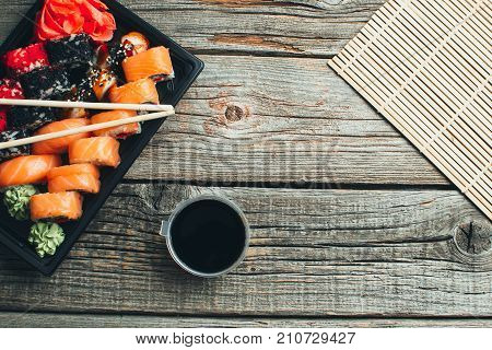 On A Wooden Table In The Black Container Are Nicely Decomposition Sushi