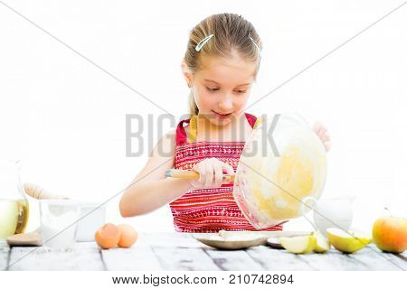 cutre little girl making dough isolated on a white background