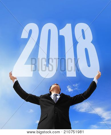 Business man holding 2018 new year imagination with sky and cloud