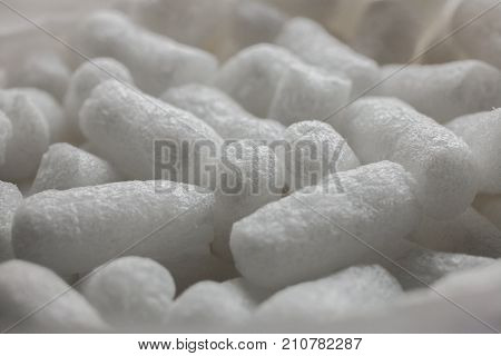 Plastic protective foam background and texture. Macro view of white packing foam background. Bubbly plastic protective granules. Closeup view of polystyrene for the protection of fragile packages