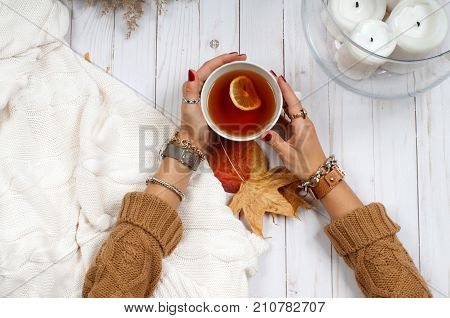 Autumn Holiday . Hands Hold Cup Of Tea On Wooden Table.