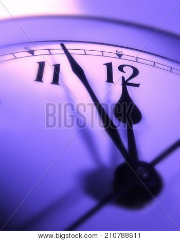 CLOSE UP OF CLOCK FACE WITH HANDS POINTING TOWARDS TWELVE O'CLOCK
