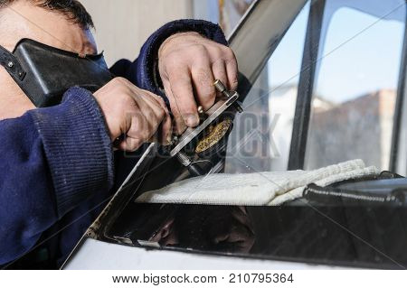 Repair cracked windshield. Fitter is using Windshield Repair Crack Bridge.