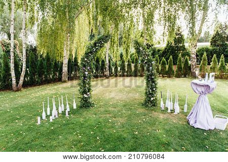Place for wedding ceremony with white chairs and an arch of living plants