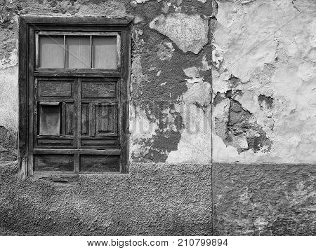detail of empty derelict small house with decaying bricks broken plaster and window