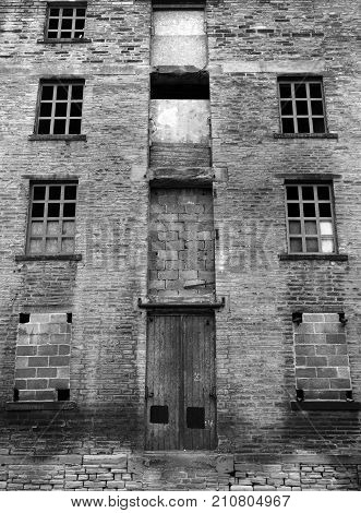 abandoned disused old derelict factory or mill building with broken windows
