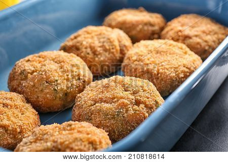 Delicious salmon patties in baking dish, closeup