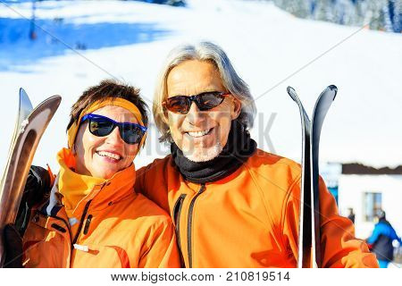 Active senior couple skiing, enjoying a clear winter day.