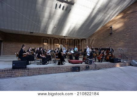 JOLIET, ILLINOIS / UNITED STATES - JUNE 1, 2017: The Metropolitan Youth Symphony Orchestra (MYSO) prepares to perform a free public concert at the outdoor theater in the Billie Limacher Bicentennial Park.