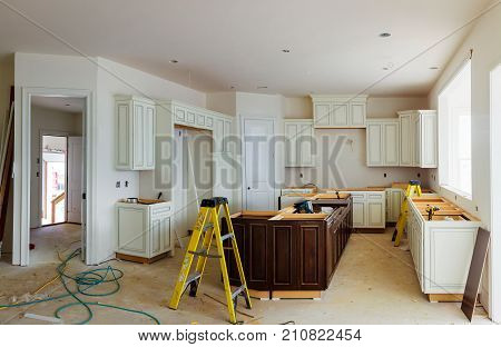 Installation of kitchen. Custom kitchen cabinets in various stages of installation base for island in center