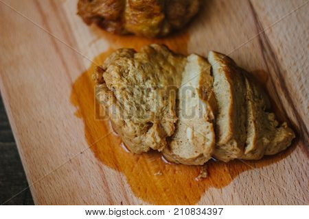 Vegetarian meat - seitan on brown wooden board.