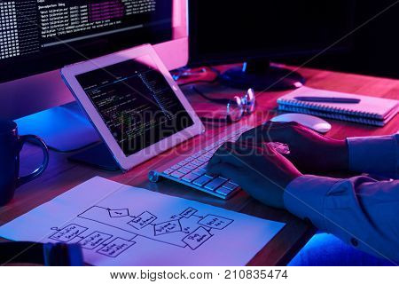 Close-up image of programmer working at his desk in office