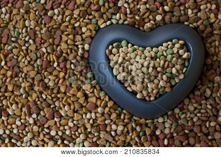 Heart bowl filled by dry pet food.