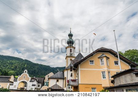 St Gilgen, Austria - August 5, 2017: Low angle view of church and historical centre of St Gilgen against the mountains and a cloudy sky