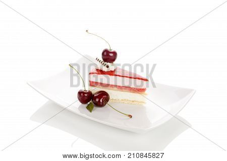 Delicious sweet cherry cake with cherries on white plate. Isolated on white background with reflection. Sweet dessert.