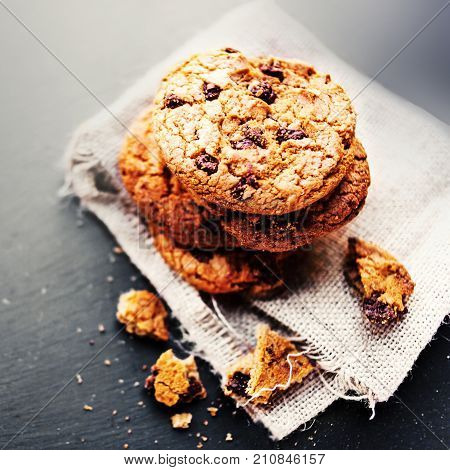 Chocolate chip cookies on dark with place for text freshly baked. Selective Focus with Copy space. Rustic styled image. Heap of tasty cookies