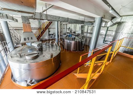 Industrial premises with installed metal cistern. Equipment for mixing sugar and yeast mixture.