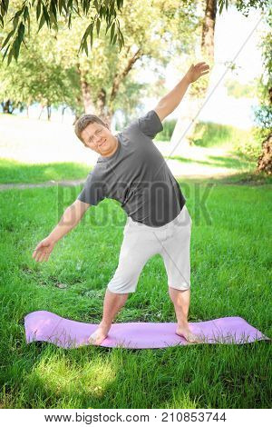 Overweight man training on green grass
