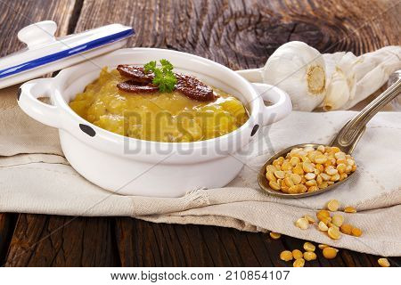 Lentil soup on wooden table with sausage. Delicious soup eating.