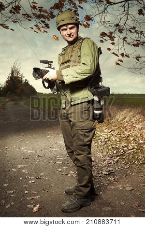 Journalist in war conflict field zone between photographing