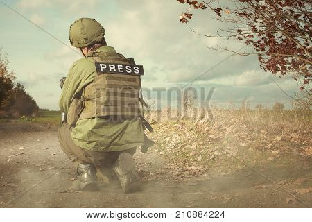 Photographer in war conflict field zone observing terrain