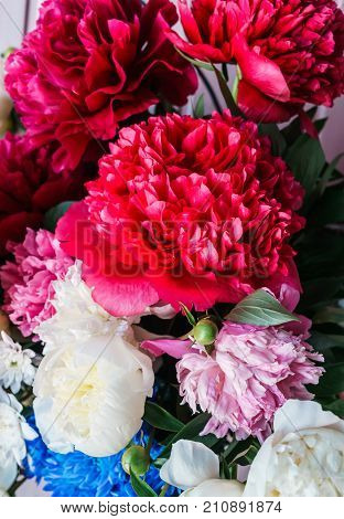 a bouquet of luxurious red peonies in a vase.