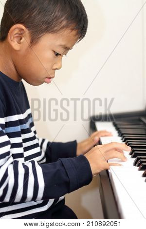 Japanese Boy Playing A Piano (second Grade At Elementary School)