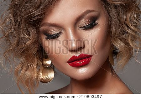 Beauty woman with beautiful make-up color . Blond hair raised hair jewelry on his neck clean skin beautiful face . Portrait shot in studio on a dark background.