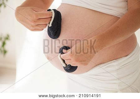 the stomach of a pregnant woman and baby stuff socks 1