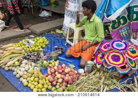 PONDICHERY PUDUCHERY INDIA - SEPTEMBER 09 2017. Unidentified man woman at his fruit and or vegetables shop in the main market of the city in south of India Asia.