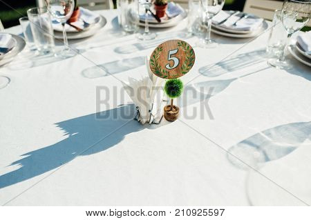 Round banquet table served to the wedding guests arrive. Solar flare on the tablecloth