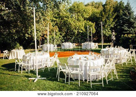 Round banquet table served to the wedding guests arrive. Solar flare on the tablecloth