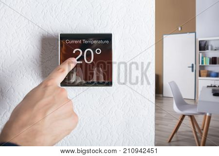 Finger Touching Digital Thermostat Temperature Controller At Home