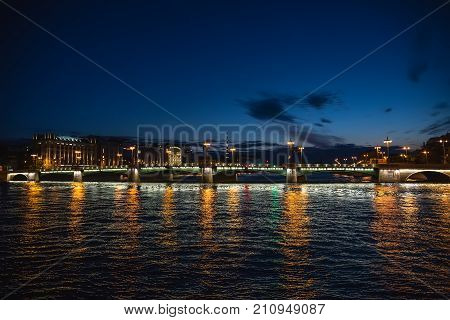 Bridge in Saint-Petersburg with lights illumination in summer white night, Neva river, toned