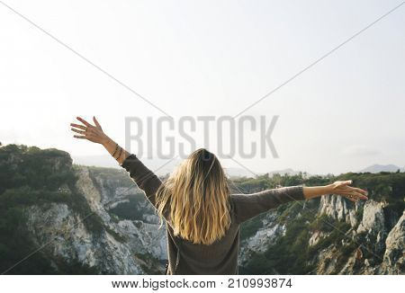 Carefree woman arms outstretched on the mountain