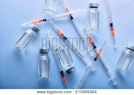 A Lot Of Vials And Syringes On Blue Table Top View