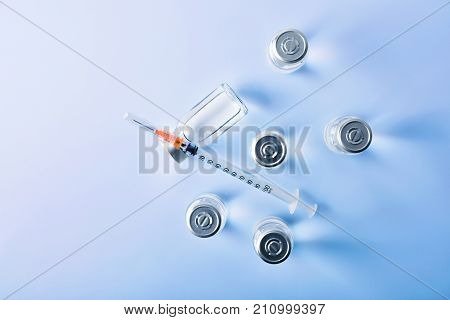 Group Of Vials And Syringe On Blue Table Top View
